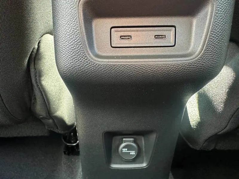 Vue rapprochée des ports USB-C et prise 12V au dos de la console centrale du Citroën C3 Aircross gris Mercury.