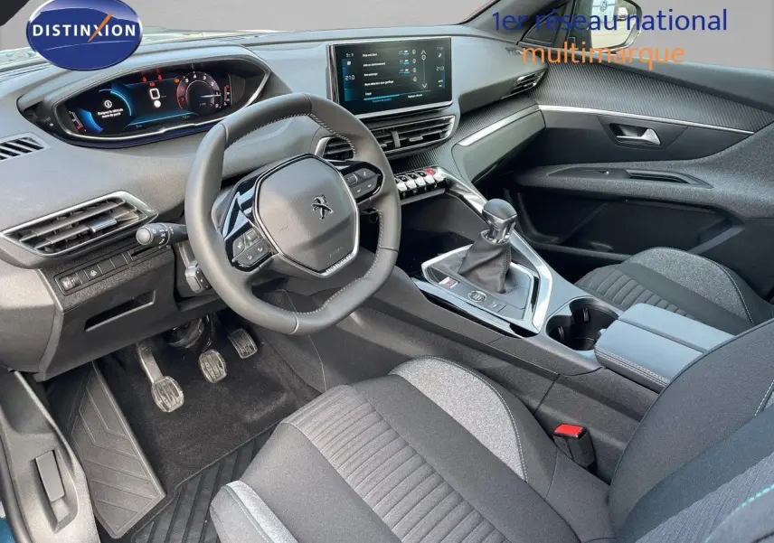 Vue intérieure côté conducteur du Peugeot 3008 2023, mettant en valeur le volant compact, la boîte manuelle et les sièges tissu gris noir.