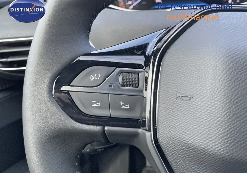 Gros plan sur les commandes gauche du volant en cuir noir du Peugeot 3008 bleu Celebes Metal 2023.