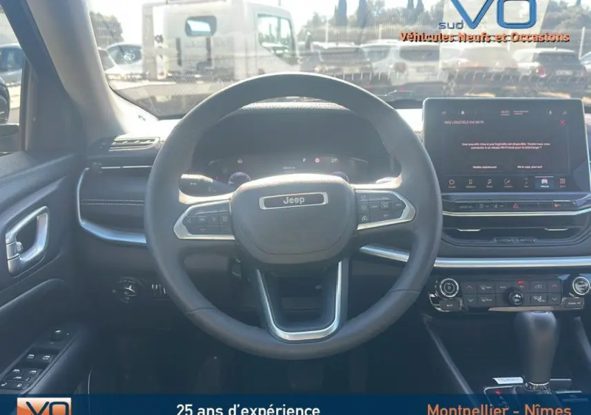 Vue intérieure centrée sur le volant Jeep Compass 2023 avec écran tactile et commandes au volant visibles