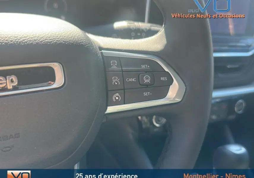 Gros plan sur le volant noir du Jeep Compass 2023 Limited avec commandes de régulateur de vitesse intégrées.