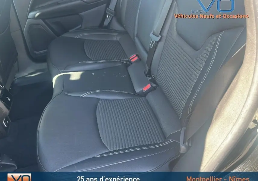 Vue rapprochée des sièges arrière noirs du Jeep Compass 2023, mettant en valeur la finition cuir et les ceintures de sécurité.