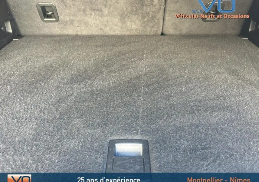 Espace de coffre du Jeep Compass noir 2023, montrant le tapis de sol et les fixations internes du coffre.