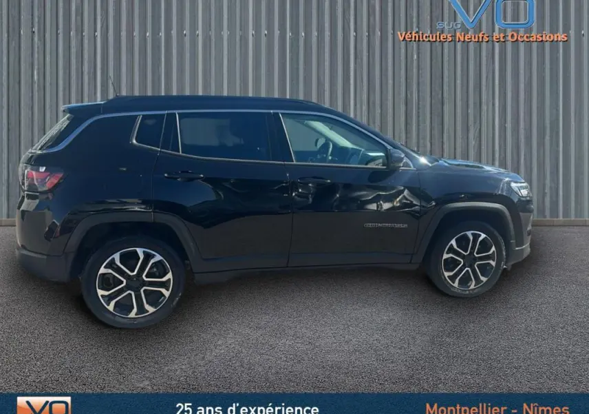 Profil latéral gauche du Jeep Compass noir 2023 avec jantes 18 pouces et barres de toit visibles.