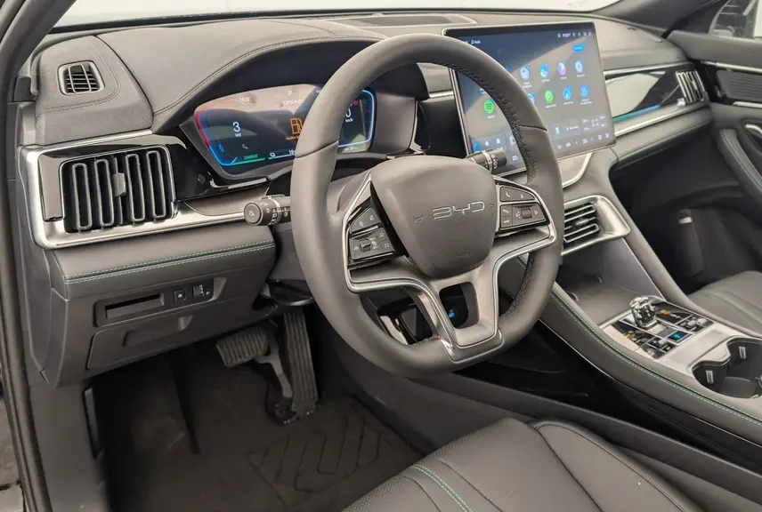 Vue intérieure côté conducteur du BYD SEAL U 2025 noir, avec volant multifonction, tableau de bord numérique et écran tactile central.