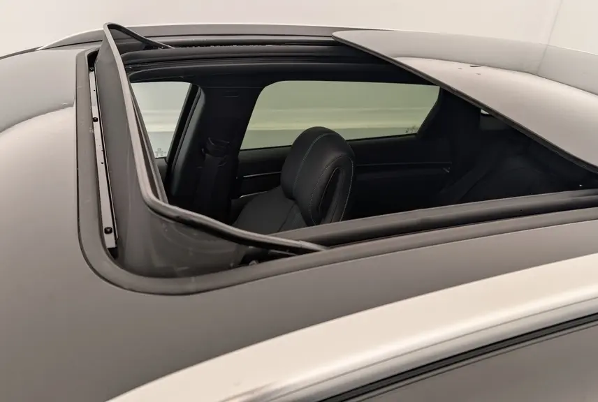 Vue rapprochée du toit ouvrant panoramique ouvert du BYD SEAL U noir obsidienne, montrant l'intérieur et le siège avant.