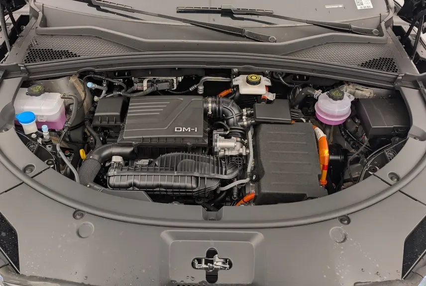 Vue rapprochée du compartiment moteur du BYD SEAL U hybride rechargeable en Obsidian Black, avec capot ouvert.
