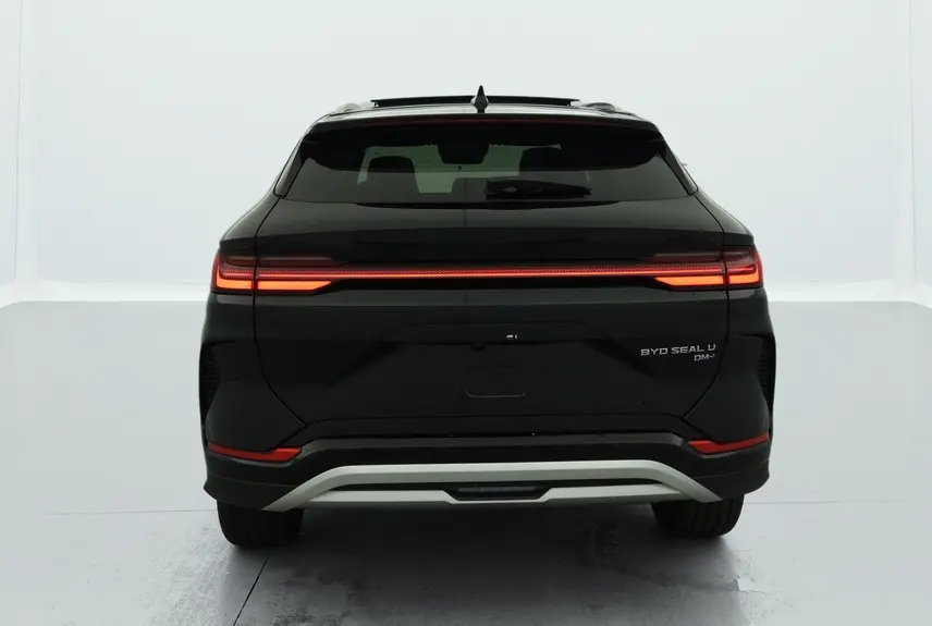 Vue arrière d’un BYD SEAL U hybride rechargeable Obsidian Black avec feux arrière LED allumés et hayon fermé.