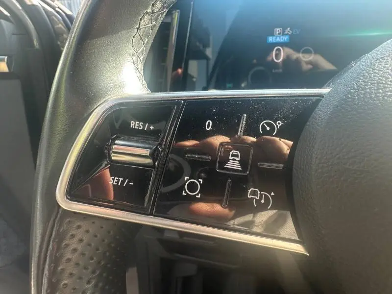 Gros plan sur les commandes au volant gauche du Renault Espace 2024 gris schiste, avec régulateur de vitesse et aides à la conduite.