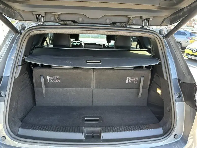 Coffre ouvert vu de l'arrière du Renault Espace 2024 gris schiste, avec cache-bagages et sièges arrière visibles.