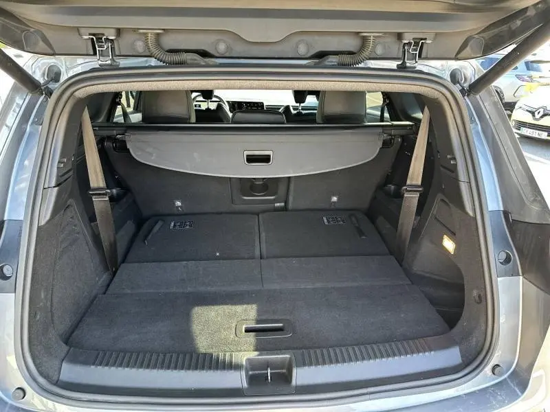 Coffre ouvert vu de l'arrière d'un Renault Espace 2024 gris schiste, montrant l'espace de chargement avec banquette rabattue.