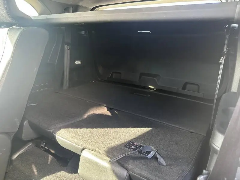 Vue intérieure du coffre arrière du Renault Espace 2024 gris, montrant la banquette rabattue et un espace de chargement plat.