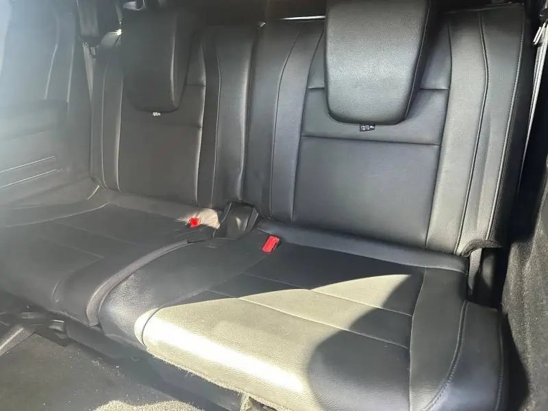 Vue intérieure de la banquette arrière en cuir noir du Renault Espace 2024, soulignant les ceintures rouges et l'implantation 7 places.