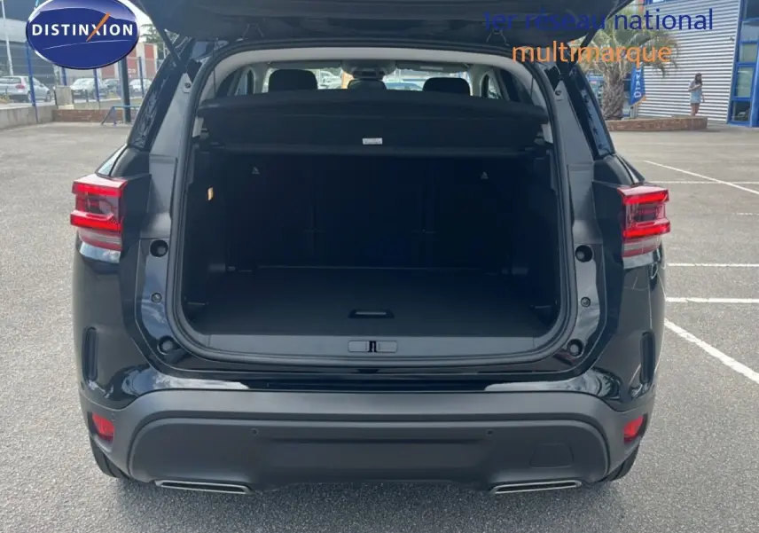 Vue arrière du Citroën C5 Aircross noir métal 2025 avec coffre ouvert et feux arrière allumés.