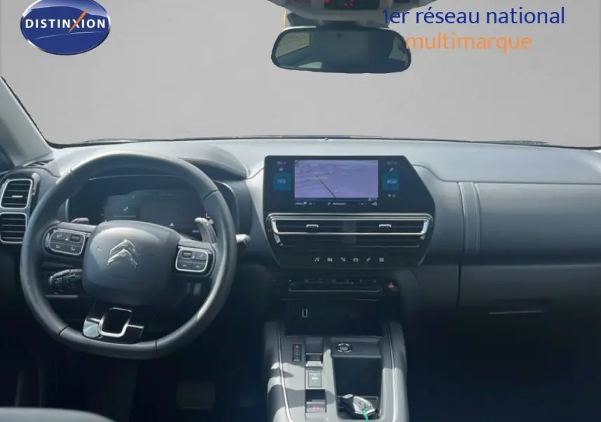 Vue intérieure frontale du tableau de bord noir du Citroën C5 Aircross 2025 avec écran tactile central et volant multifonction.