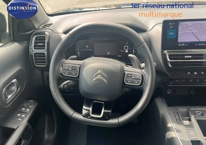 Vue intérieure centrée sur le volant et le tableau de bord du Citroën C5 Aircross noir métal, avec écran tactile et commandes intégrées.
