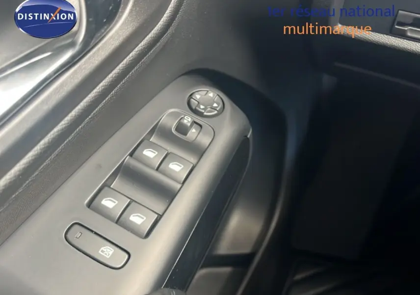 Gros plan sur les commandes des vitres électriques côté gauche de la porte d’un Citroën C5 Aircross noir métal 2025.