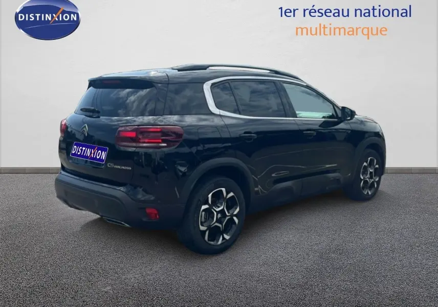 Vue 3/4 arrière droite d'un Citroën C5 Aircross noir métal 2025, hybride essence avec jantes distinctives.