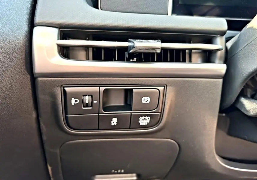 Détail intérieur côté conducteur du Hyundai Tucson 2026, montrant les commandes d’éclairage et de frein à main électronique.