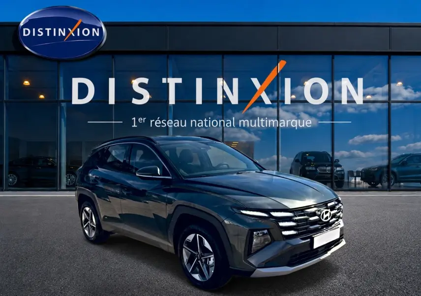 Hyundai Tucson hybride vert vue 3/4 avant droit devant showroom Distinxion avec jantes alu 18 pouces.
