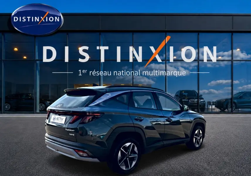 Vue 3/4 arrière droite du Hyundai Tucson 1.6 t-gdi 239 hybride vert, avec jantes alliage et lignes anguleuses marquées.
