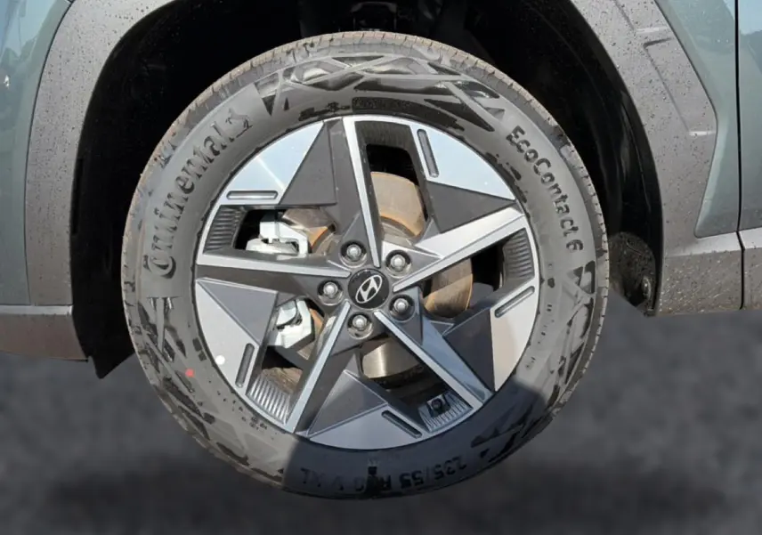 Gros plan sur la roue avant droite du Hyundai Tucson vert 2026 avec jante alu au design moderne et logo Hyundai central.