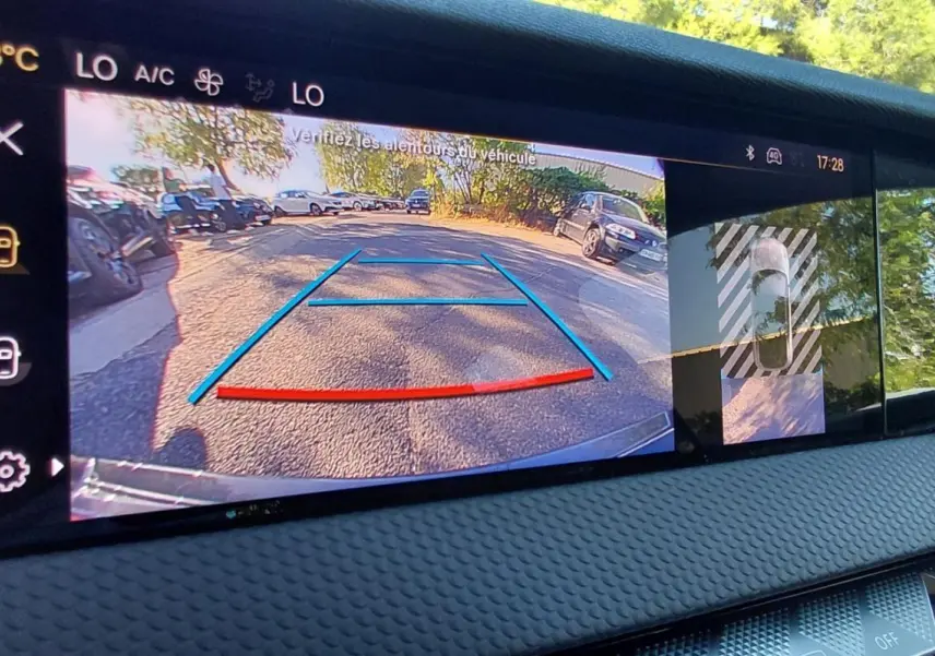 Écran intérieur du DS4 2024 Hybride E-Tense montrant la caméra de recul avec lignes de guidage colorées et vue 360° du véhicule.