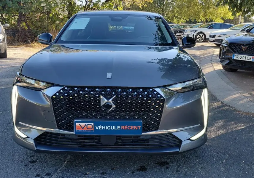 Vue frontale du DS4 Hybride E-Tense 225 gris 2024, avec calandre distinctive et feux diurnes en forme de dents de sabre.