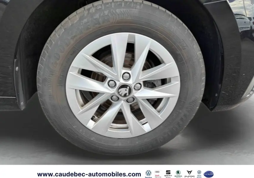 Gros plan sur la jante alliage 15'' argent avec logo ŠKODA, roue avant droite d'une Fabia noire 2025.