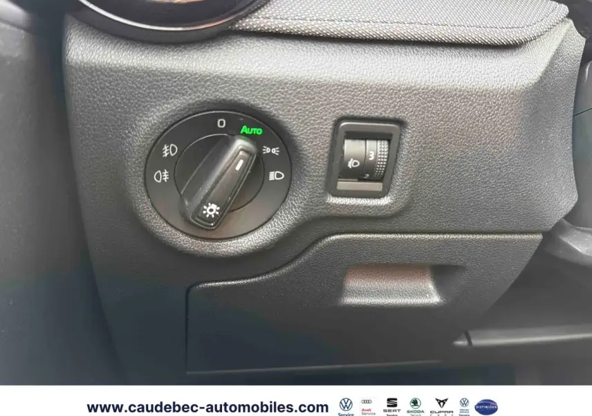 Gros plan sur le panneau de commande des phares noirs à gauche du tableau de bord d'une Skoda Fabia 2025.