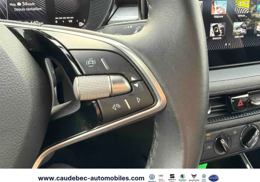 Gros plan sur le volant cuir multifonctions et la console centrale avec écran tactile du Skoda Fabia noir 2025.