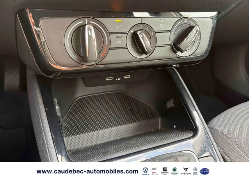 Vue rapprochée des commandes de climatisation manuelle et des ports USB-C sur la console centrale noire d'une Skoda Fabia.