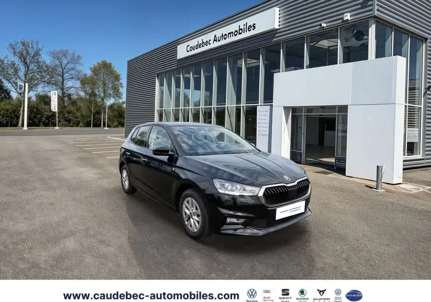 SKODA Fabia noire vue en 3/4 avant, stationnée devant un bâtiment moderne de concession automobile.