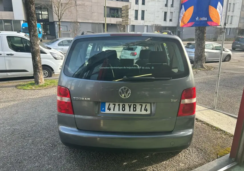 Vue arrière d'un Volkswagen Touran gris 2004 avec plaques françaises, feux rouges et hayon vitré.