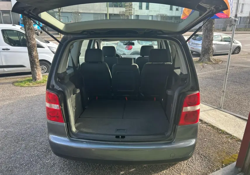 Vue arrière d'un Volkswagen Touran gris 2004 avec coffre ouvert et sièges arrière visibles.