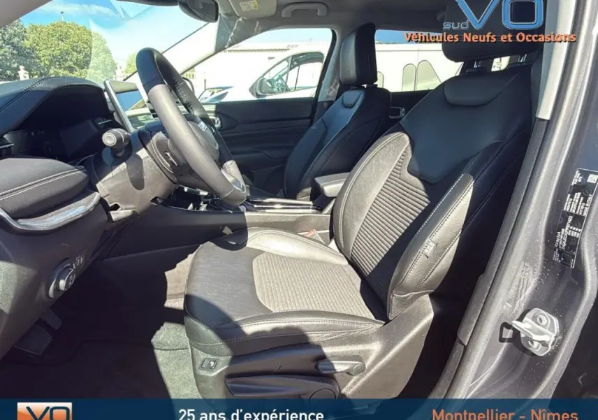 Vue intérieure côté conducteur du Jeep Compass gris 2023, sièges en cuir et tableau de bord moderne avec écran tactile.