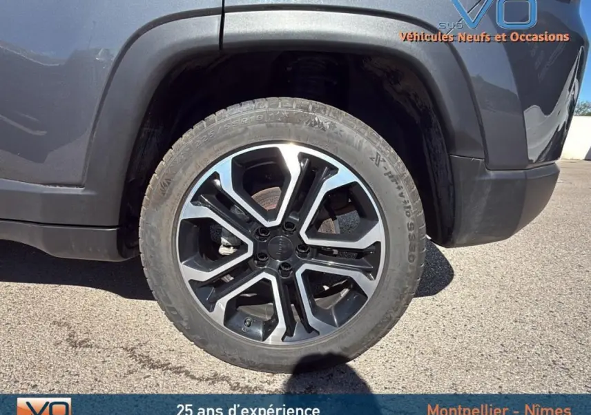 Gros plan sur la roue avant gauche du Jeep Compass gris 2023 avec jante alliage 18 pouces au design moderne.