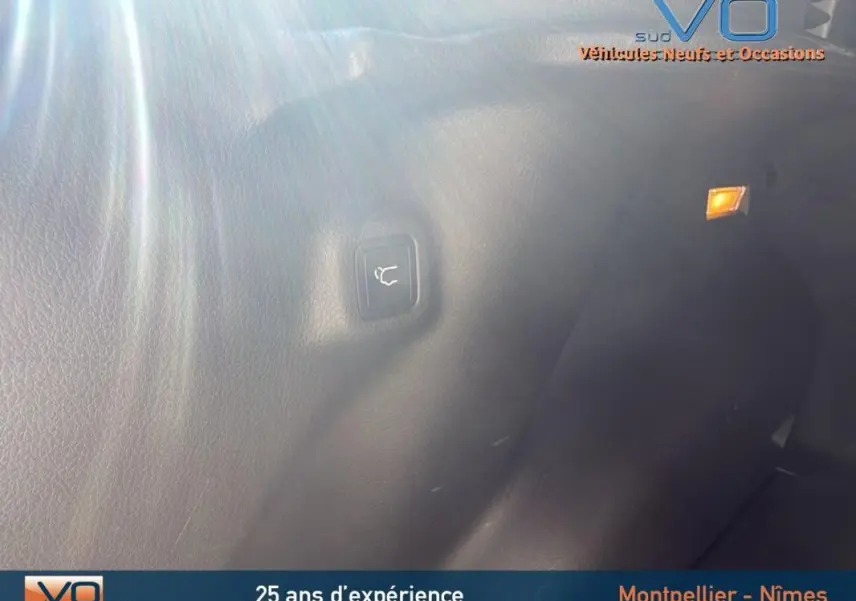 Bouton d'ouverture du coffre sur la garniture intérieure arrière d'un Jeep Compass gris 2023.