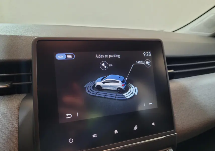 Écran tactile central de la Renault Clio gris foncé affichant l'aide au parking avec vue 3D du véhicule.