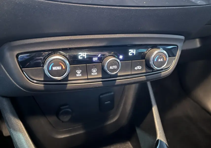 Gros plan sur la commande de climatisation automatique bi-zone de l’Opel Crossland X 2021, intérieur noir.