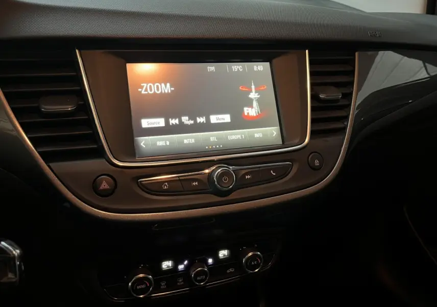 Tableau de bord intérieur de l’Opel Crossland X 2021 avec écran tactile central allumé et commandes de climatisation digitales.