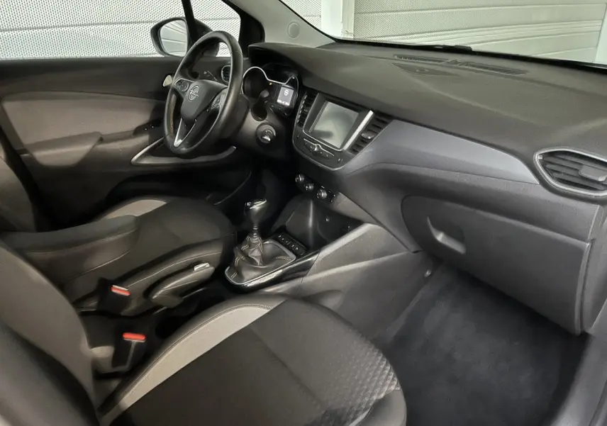 Vue intérieure côté passager de l’Opel Crossland X 1.2 Turbo 2021, tableau de bord noir avec écran tactile central.