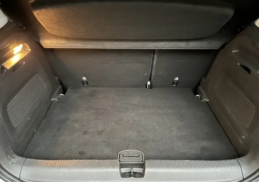 Vue du coffre arrière noir de l’Opel Crossland X blanc, montrant l’espace de chargement avec plancher plat et éclairage intérieur.