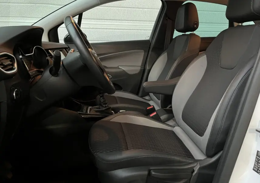 Vue intérieure côté conducteur de l'Opel Crossland X 2021, sièges bi-ton noirs et gris avec volant cuir multifonctions.