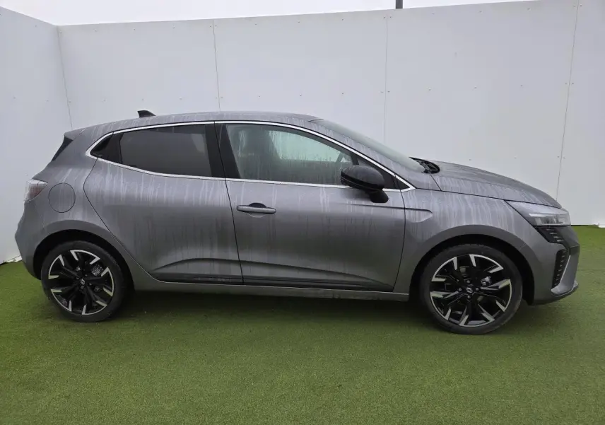 Profil droit de la Renault Clio 2025 gris schiste métal avec jantes alliage noires et vitres surteintées.