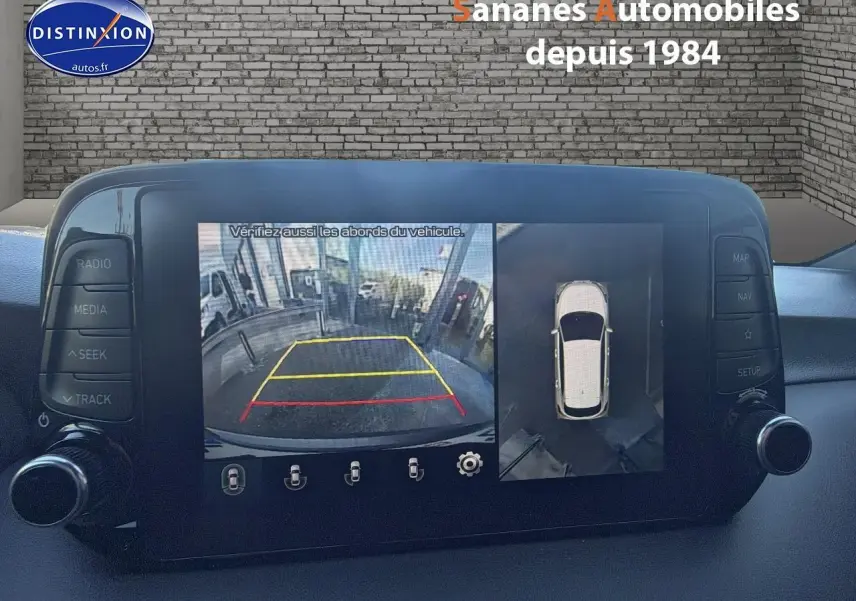 Vue intérieure sur l’écran tactile du Hyundai Tucson gris foncé montrant la caméra 360 et l’aide au stationnement arrière.