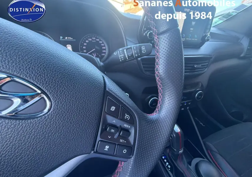 Vue intérieure centrée sur le volant cuir perforé avec surpiqûres rouges et tableau de bord du Hyundai Tucson N Line 2020.
