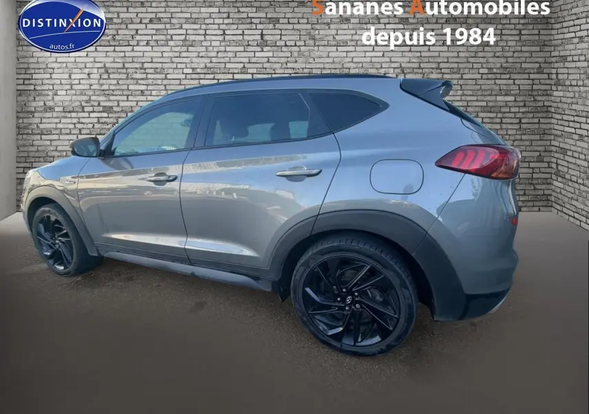 Vue latérale gauche d'un Hyundai Tucson 1.6 Hybrid 136 N Line gris foncé avec jantes alliage noires.