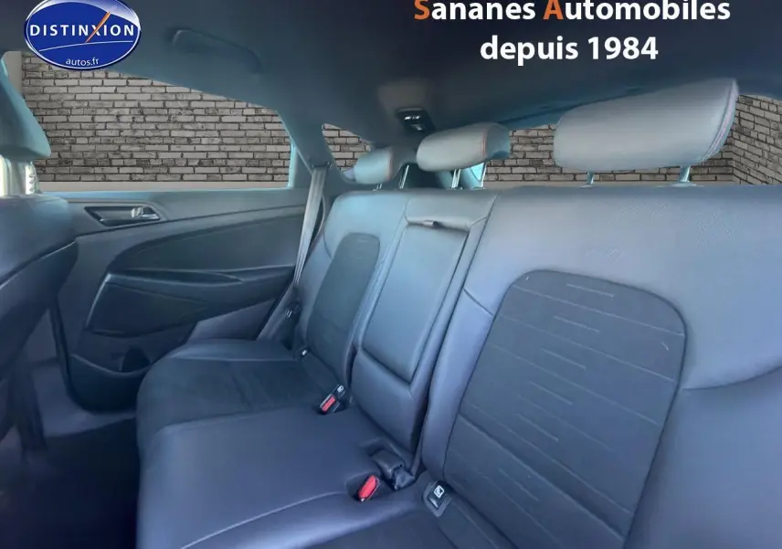 Vue intérieure arrière du Hyundai Tucson 1.6 Hybrid 136 N Line 2020, montrant les sièges cuir/alcantara gris foncé avec surpiqûres rouges.