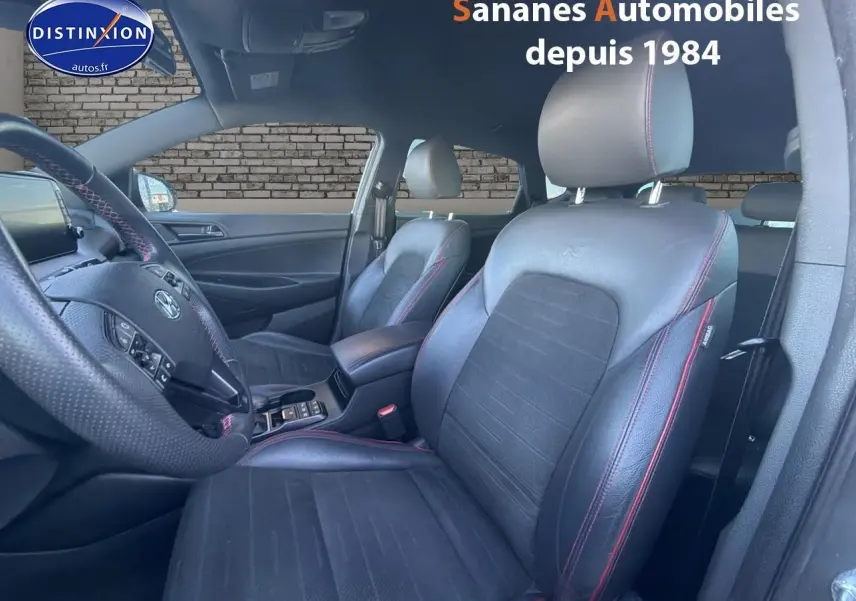 Vue intérieure côté conducteur du Hyundai Tucson N Line 2020, sièges cuir noir avec surpiqûres rouges visibles.